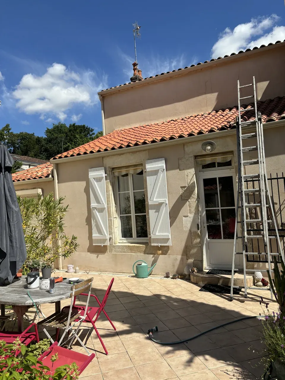 Façade en cours de rénovation avec une échelle contre le mur